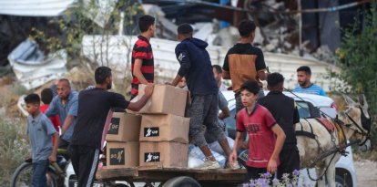 Personas transportan suministros de ayuda de la Fundación Humanitaria de Gaza (FGH)