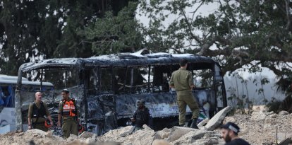 Israeli security and emergency service members deploy at the impact site of an Iranian missile at a bus depot in Herzliya near Tel Aviv on June 17, 2025.