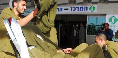 Un soldado israelí herido se cubre la cara al llegar al hospital Beershevas Soroka tras la explosión de un jeep del ejército en el paso fronterizo de Kissufim, entre Israel y la Franja de Gaza, el 27 de enero de 2009, en la que murió un soldado y otros tres resultaron heridos.