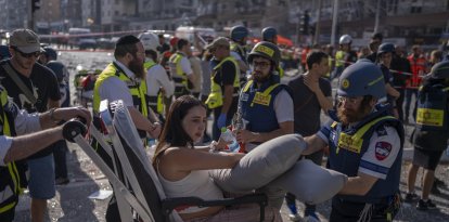Israeli paramedics assist a woman injured following an Iranian attack.
