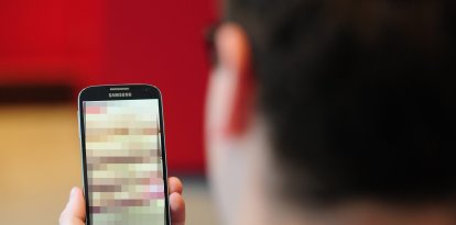 Una persona viendo un teléfono con contenido censurado