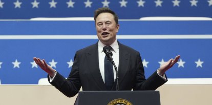 Elon Musk dando un discurso con el atril presidencial