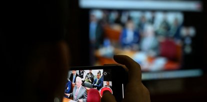 Un periodista graba una de las audiencias contra Álvaro Uribe.