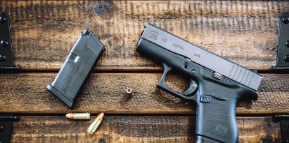 Una pistola Glock con municiones sobre una mesa (Archivo)