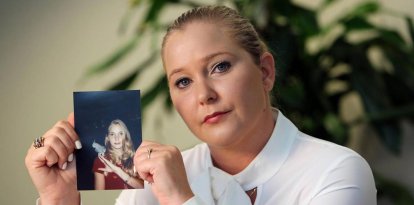 Virginia Giuffre, víctima de Epstein, sosteniendo una foto suya de adolescente