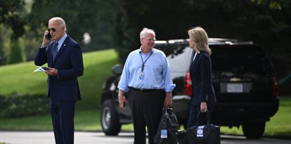 Mike Donilon y Liz Sherwood-Randall, exasesores de Joe Biden, hablando detrás del expresidente