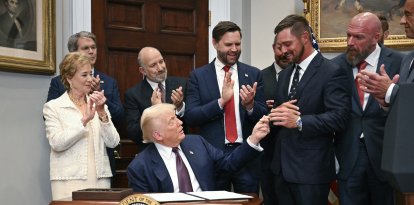 Donald Trump bromea con el golfista Bryson DeChambeau durante la firma