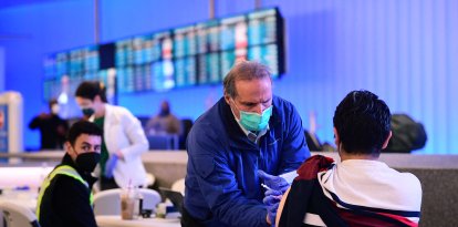 The Covid-19 vaccine is administered in the international arrivals section of Los Angeles International Airport