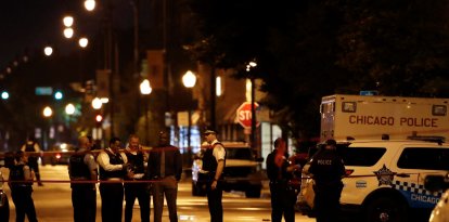 Chicago Police officers investigate the scene of a shooting in Chicago, Illinois, on July 21, 2020. A shootout outside a funeral left 14 people wounded July 21 in Chicago, as President Donald Trump threatens to send federal agents to a handful of US cities led by Democratic mayors. (Photo by KAMIL KRZACZYNSKI / AFP)