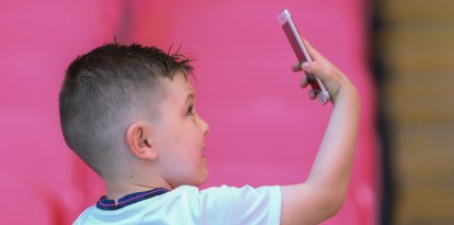 Un niño se fotografía con un celular. Imagen de archivo