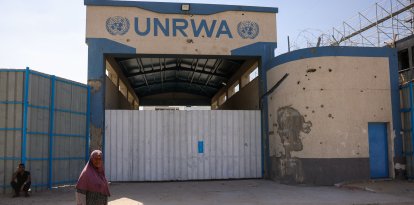 A woman walks past the closed UN agency for Palestinian refugees UNRWA