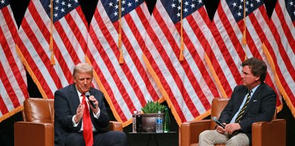 El expresidente estadounidense y candidato presidencial republicano Donald Trump (izquierda) habla durante una entrevista en directo con el comentarista estadounidense Tucker Carlson en la final de la gira Tucker Carlson Live Tour en el Desert Diamond Arena de Glendale, Arizona, el 31 de octubre de 2024.