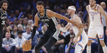 El delantero de los San Antonio Spurs, Victor Wembanyama (1), cruza el balón por la cancha contra el base del Oklahoma City Thunder, Alex Caruso (9), durante la segunda mitad en el Paycom Center.