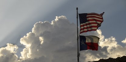 La bandera de los Estados Unidos y la bandera del estado de Texas se exhiben en el parque Murchison Rogers a lo largo de Scenic Drive al atardecer el 24 de junio de 2021 en El Paso, Texas.