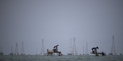 Oil rigs are pictured in Lake Maracaibo, Zulia State, Venezuela on July 12, 2024. A putrid smell hangs over the black-stained shores of Lake Maracaibo in Venezuela, where an oil slick is emblematic of the steep decline in the country's once-enviable petroleum industry. Here, much like elsewhere in what was once Latin America's richest country, economic hardship drives much of the discussion ahead of the July 28 elections, in which President Nicolas Maduro will seek a third six-year term. (Photo by Federico PARRA / AFP)