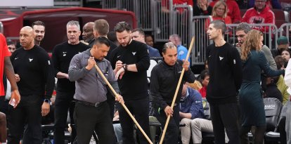 Los empleados del United Center limpian la cancha durante una pausa antes de un partido de baloncesto de la NBA entre los Chicago Bulls y los Miami Heat en Chicago, el jueves 8 de enero de 2026. (AP Photo/Nam Y. Huh)