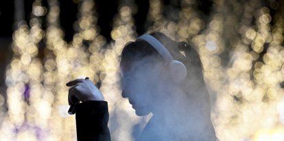 Una joven fuma un cigarrillo electrónico