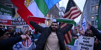 Un manifestante rompe la bandera de la República Islámica de Irán.