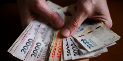 (Archivo) Una manos sostiene billetes argentinos