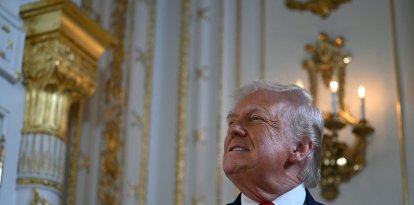US President Donald Trump arrives to take part in a dedication ceremony for Southern Boulevard, in the ballroom at Mar-a-Lago in Palm Beach, Florida, on January 16, 2026. (Photo by ANDREW CABALLERO-REYNOLDS / AFP)