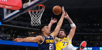 El alero de los Denver Nuggets, Spencer Jones (21), comete una falta sobre el alero de Los Angeles Lakers, Luka Dončić (77), durante la primera mitad de un partido de baloncesto de la NBA el martes 20 de enero de 2026 en Denver.