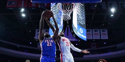 Joel Embiid (21), de los Philadelphia 76ers, intenta un rebote contra Josh Okogie (20), de los Houston Rockets, durante la primera mitad de un partido de la NBA el jueves 22 de enero de 2026 en Filadelfia. (Foto AP/Matt Slocum)