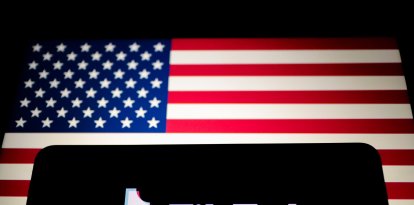 El logotipo de TikTok se muestra en un smartphone junto a la bandera de Estados Unidos. TikTok es una aplicación lanzada en 2016 por ByteDance, una empresa tecnológica china.