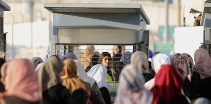 Palestinos avanzan a través del puesto de control de Qalandia.