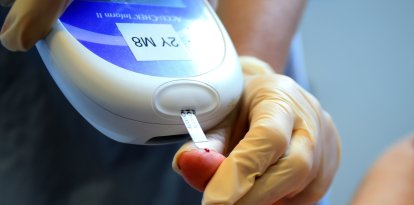 A nurse giving a patient a diabetes test.