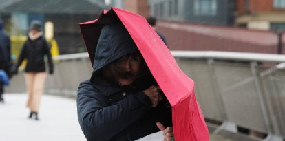 Una persona con un paraguas cruza el puente Sean O'Casey en una tarde lluviosa y ventosa en Dublín, mientras entra en vigor una alerta naranja por lluvia como consecuencia de la tormenta Claudia. Fecha de la fotografía: viernes, 14 de noviembre de 2025.