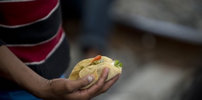 Un inmigrante latino sostiene un taco mexicano (Archivo)