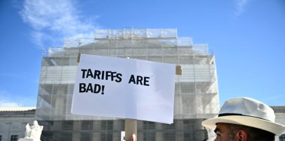 Un manifestante sostiene un cartel que dice "Los aranceles son malos" frente a la Corte Suprema de Estados Unidos en Washington, D.C.