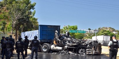 Firefighters extinguish the fire of a truck that was set on fire on a street in the port of Acapulco, Guerrero state on February 22, 2026. The Mexican army announced the death of powerful drug lord Oseguera Cervantes, for whom the United States was offering a £12 million reward, adding in a statement that El Mencho was wounded in an operation carried out in the town of Tapalpa, in the western state of Jalisco, and died during his transfer by air to Mexico City. (Photo by Francisco ROBLES / AFP)