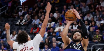 El base de los Detroit Pistons, Cade Cunningham (2), lanza un tiro en suspensión contra el base de los Cleveland Cavaliers, Craig Porter Jr. (9), durante la primera mitad de un partido de baloncesto de la NBA el viernes 27 de febrero de 2026 en Detroit.