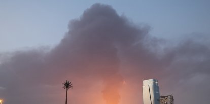 Una alta columna de humo negro se eleva tras una explosión en la zona industrial de Emiratos