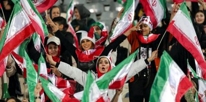 Las aficionadas al fútbol ondean banderas nacionales iraníes mientras animan a su selección (Archivo)
