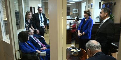US Senate Minority Leader Chuck Schumer (lower R), Democrat from New York, huddles with Senate Democrats before a news conference