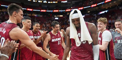 Bam Adebayo, con una toalla en la cabeza, felicitado por sus compañeros tras anotar 83 puntos frente a los Wizards