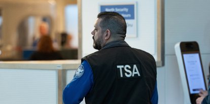 Un agente de la Administración de Seguridad del Transporte (TSA) trabaja en un puesto de control de seguridad