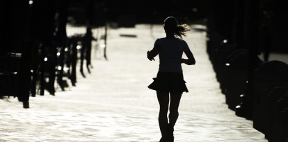 Una mujer corre por una calle de la ciudad haciendo ejercicios