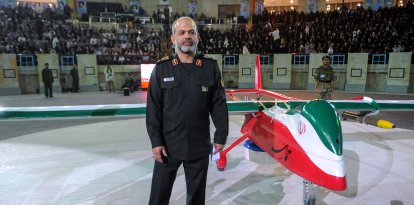 El ministro de Defensa iraní, Ahmad Vahidi, posa junto al nuevo dron de fabricación iraní «Epic» durante una ceremonia celebrada en Teherán el 9 de mayo de 2013. Irán presentó el nuevo dron denominado «Epic», capaz de llevar a cabo misiones tanto de vigilancia como de ataque, según informó la agencia de noticias Mehr. El dron, que también es un modelo furtivo, tiene un largo alcance y está equipado con misiles aire-aire, afirmó el general Amir-Farzad Esmaili, comandante de operaciones antiaéreas.