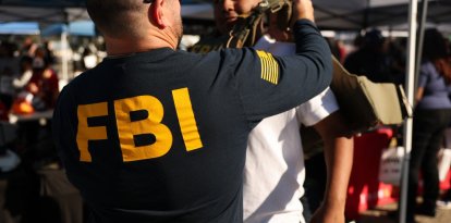 A student tries on a Federal Bureau of Investigation (FBI) vest while learning about jobs with the agency during the 10th annual Aviation Career Day at Los Angeles International Airport (LAX) in Los Angeles, California on October 30, 2025. (Photo by Patrick T. Fallon / AFP)