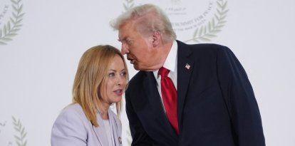 El presidente Trump dice algo al oído a la primer ministro de Italia Giorgia Meloni