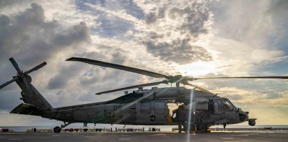 Marineros estadounidenses realizan tareas de mantenimiento previo al vuelo en un helicóptero MH-60S Sea Hawk, adscrito al Escuadrón de Combate Marítimo de Helicópteros (HSC) 25, en la cubierta de vuelo del buque de asalto anfibio de la clase America USS Tripoli (LHA 7) durante la Operación Epic Fury, el 31 de marzo de 2026.