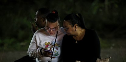 Dos mujeres hispanas con un celular en la mano (Archivo)