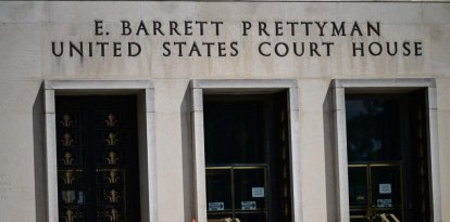 Members of the media and protesters calling for the impeachment of President Donald Trump gather at the E. Barrett Prettyman United States Court House in Washington, DC, United States, on April 27, 2026. This gathering takes place in advance of the arraignment of 31-year-old Cole Allen, who is accused of opening fire at the White House Correspondents' Association dinner over the weekend. Local and federal law enforcement are positioned outside the courthouse prior to Allen's appearance. (Photo by Kyle Mazza/NurPhoto) (Photo by Kyle Mazza / NurPhoto via AFP)