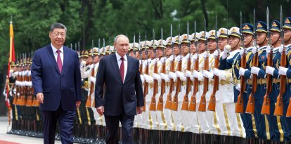 En esta fotografía de agencia distribuida por la agencia estatal rusa Sputnik, el presidente de Rusia, Vladímir Putin (centro), y el presidente de China, Xi Jinping (izquierda), pasan revista a la guardia de honor durante una ceremonia de bienvenida celebrada en el Gran Salón del Pueblo de Pekín el 20 de mayo de 2026. (Foto de Alexander KAZAKOV / POOL / AFP)