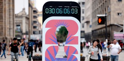 En la imagen se ve un reloj que marca los días que faltan para la Copa Mundial de la FIFA 2026, mientras personas y turistas caminan por Guadalajara