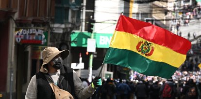 Un boliviano sostiene una bandera durante una manifestación contra el presidente Rodrigo Paz (Archivo)