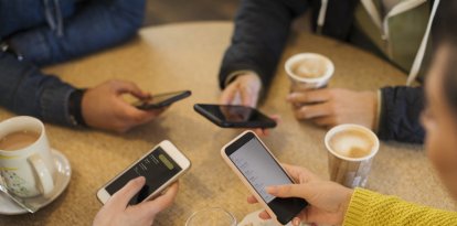 Adultos usando sus teléfonos móviles (Archivo)